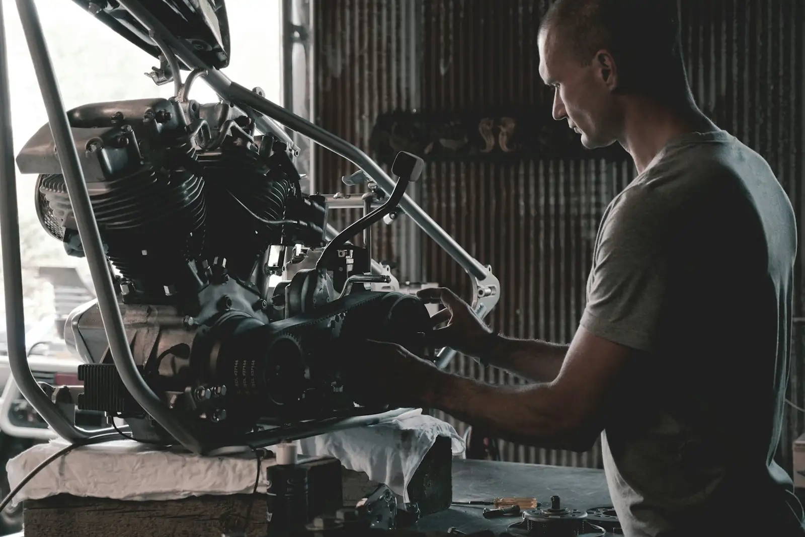 A mechanic working on an engine at the bench in a small workshop